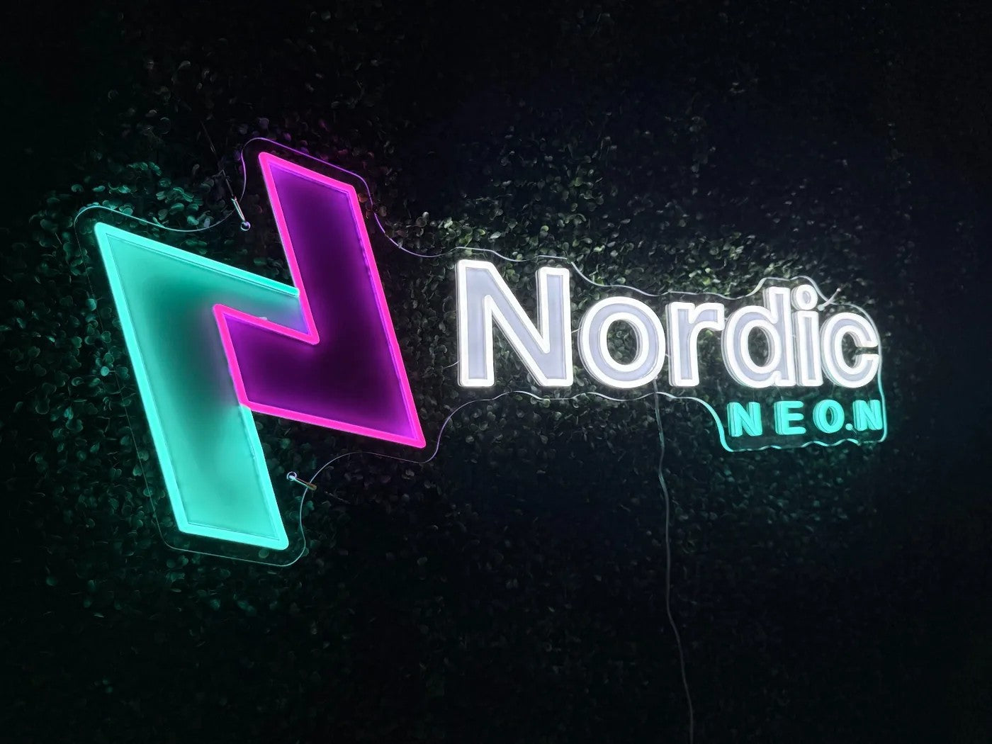 Nordic Neon Logoschild an der Pflanzenwand